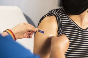 Women getting band aid on arm after flu shot