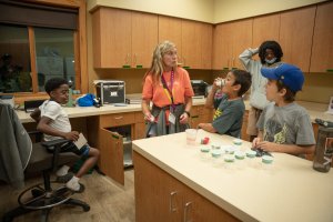 staff member with young campers in the camp office