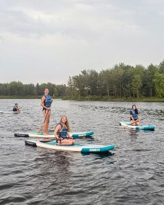 Campers on paddle boards in the lake