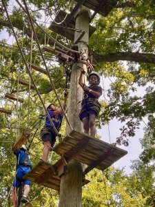 Young camper doing the tree-tops rope course