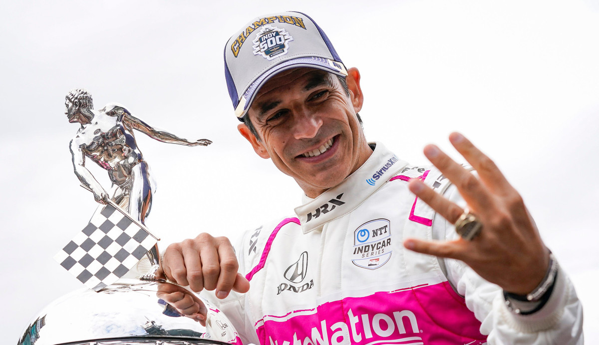 Indy Race car driver Helio Castroneves holding Indy trophy and four fingers for his 4 wins
