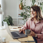 mature woman sitting in the comfort of her home office and working, social distancing concept.