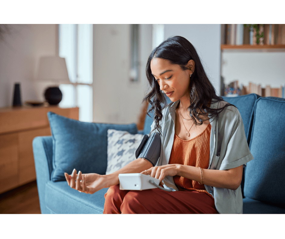 Stock image of a woman taking her blood pressure at home.